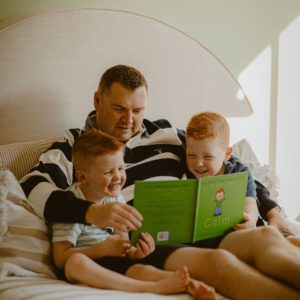 Photo of a dad reading to 2 his two sons. They're reading How Does Your Body Feel? My Body Feels Calm.
